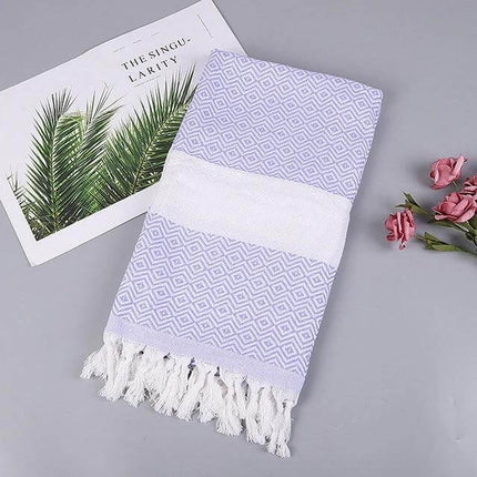 Striped Cotton Bath Towel With Tassels For Everyday Use folded lavender striped cotton-linen towel with white band and tassels on gray background