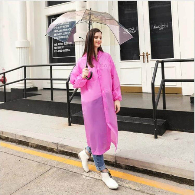Transparent Disposable Raincoat for Hiking and Outdoor Activities model wearing pink PEVA raincoat and clear umbrella on city street