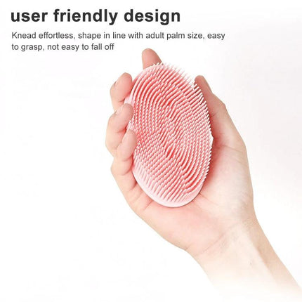 Soft Silicone Brush For Gentle Massage During Baby Bath Time - pink flexible silicone baby bath brush held in hand for gentle cleansing and soothing