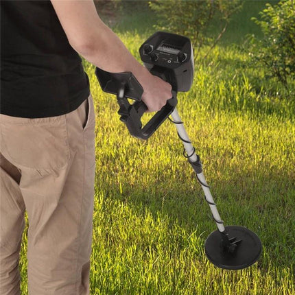 Portable Underground Metal Detector for Outdoor Treasure Hunting in hand detecting coins on grass with simple controls