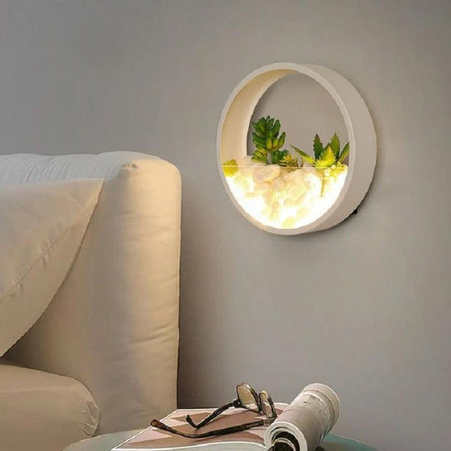 Decorative Wall Lamp for Bedside and Living Room Settings — round wall sconce with soft light and small succulents creating cozy bedside ambiance