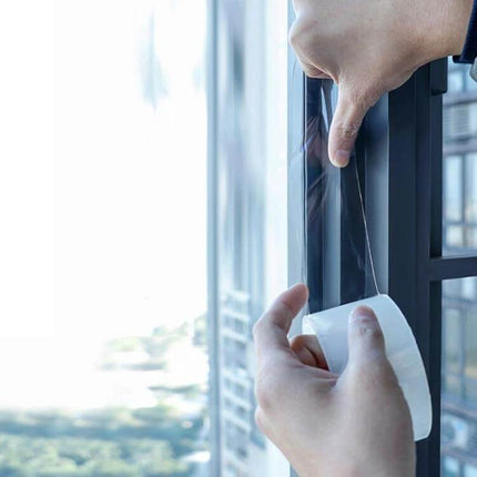 Nano PET Window Gap Tape, 5 cm x 15 m For Home Windows applied to seal window frame gap, clear adhesive strip being unrolled and pressed into place