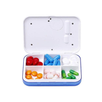 Electronic Pill Box Six-Grid Reminder for Daily Meds open showing six compartments with assorted pills for travel and daily dosing reminders