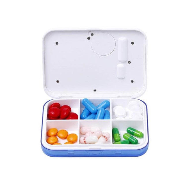 Electronic Pill Box Six-Grid Reminder for Daily Meds open showing six compartments with assorted pills for travel and daily dosing reminders