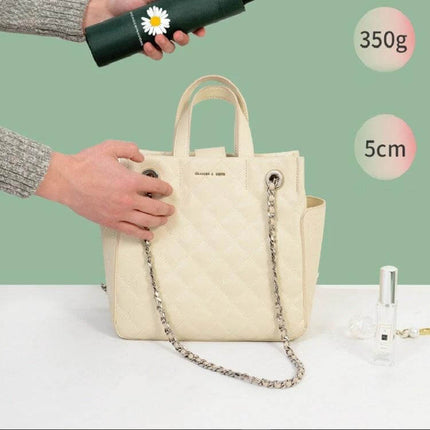 GD Daisy Folding Umbrella for Sun and Rain Protection compact dark green umbrella held above cream handbag, 350g, 5cm folded