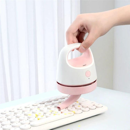 Compact USB Charging Vacuum for Desktop and Keyboard Cleaning handheld pink vacuum cleaning crumbs from white keyboard, portable USB-powered desk cleaner