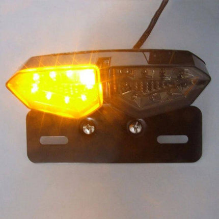 Motorcycle LED Tail Light with Integrated Brake and Turn Signals mounted on metal bracket, amber turn signal illuminated, DC12-14V ABS housing
