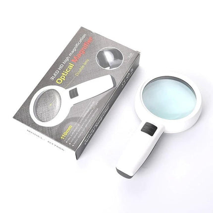 Handheld Magnifying Glass with LED Light for Elderly Reading placed next to packaging, white magnifier with built-in LED and large round lens