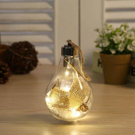 LED Transparent Christmas Ball Ornaments 2 Pack For Tree glowing clear LED bulb-shaped ornament with warm lights on table