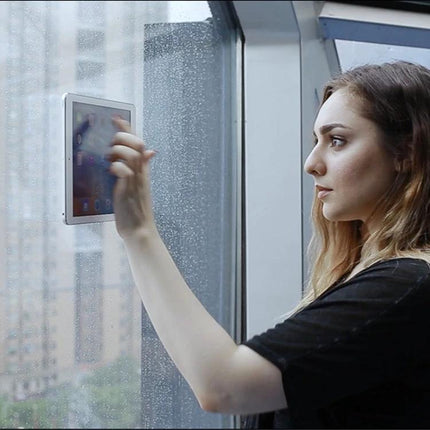 Universal Wall-Mounted Magnetic Holder for iPads and Phones attached to window holding iPad for hands-free viewing
