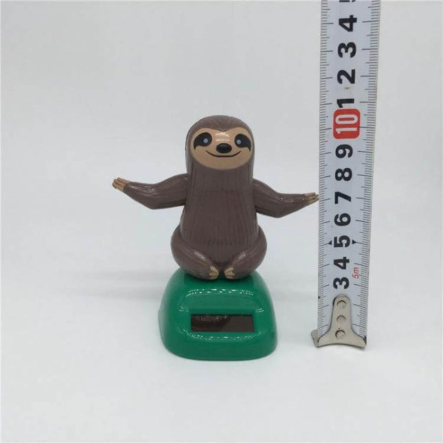 Solar Powered Dancing Sloth Toy for Car Dashboard Decoration - compact solar dashboard sloth bobbing figure on green base with ruler