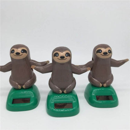 Solar Powered Dancing Sloth Toy for Car Dashboard Decoration — Three brown sloth figures on green solar bases, ideal dashboard or desk ornament