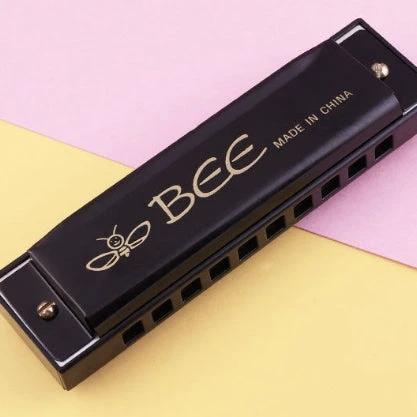 BEE's Compact Harmonica for Daily Music and Travel Use handheld black harmonica on pastel background