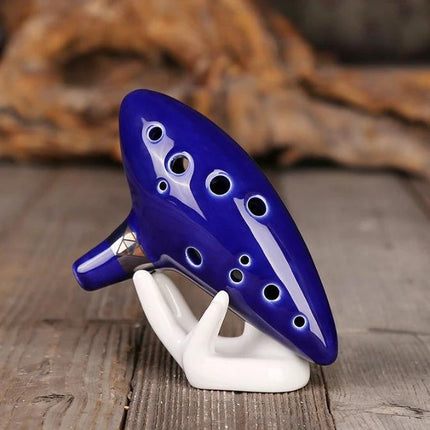 Ocarina for Beginner Musicians to Enjoy Music at Home - blue glazed ceramic ocarina on a white display stand for casual home practice