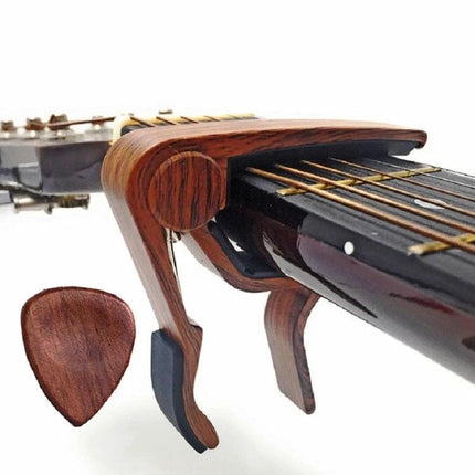 Essential Wooden Guitar Capo and Picks for Daily Practice wooden capo clamped on guitar neck with matching wood pick