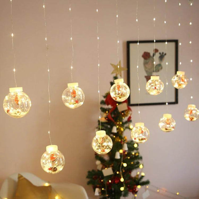Led Copper Wire Curtain Lights With Wishing Ball For Christmas Decor hung over a room with hanging glowing wishing ball ornaments and a decorated Christmas tree