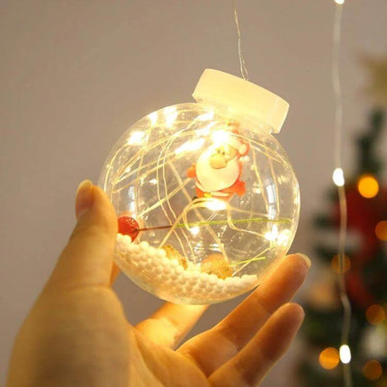 Hand holding a glowing ornament showcasing Led Copper Wire Curtain Lights With Wishing Ball For Christmas Decor wrapped inside a clear festive ball