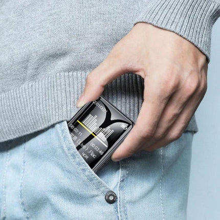 Person sliding M21 1.77 Inch Touch Screen MP3 Player for E-Books and Music into jeans pocket, showing compact touchscreen and music display