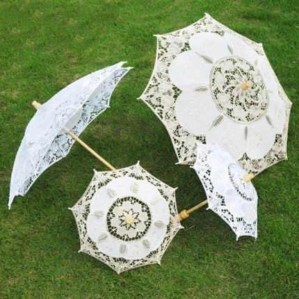 Elegant Bridal Lace Umbrella for Weddings and Photo Sessions White lace parasols with wooden handles on grass