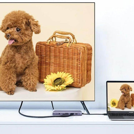 Type-C Multi-Function Docking Station for Charging and Connecting showing laptop to monitor connection with USB3.0 hub and travel props