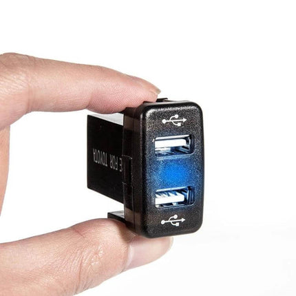 Toyota Car Charger With Dual USB Ports For In Vehicle Use compact black dual-USB plug showing two ports held between fingers