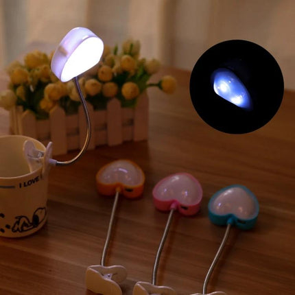 Heart-Shaped Clip Light for Evening Reading and Study clipped to a mug illuminating a book for late-night reading