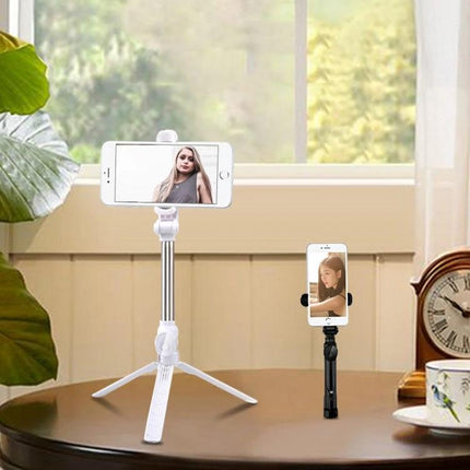Tripod Selfie Stick for Everyday Photos and Group Shots showing white tripod selfie stick holding phone on tabletop for hands-free group photos and videos