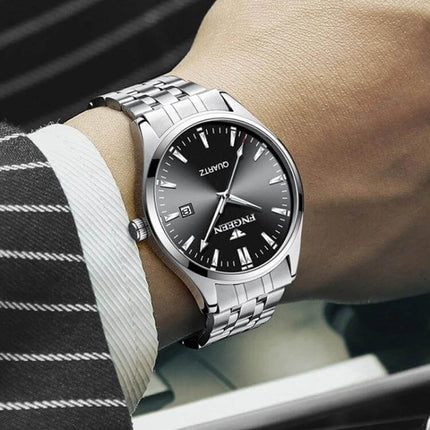FNGEEN Men's Luminous Calendar Watch for Everyday Use stainless steel silver bracelet on wrist showing luminous black dial and calendar