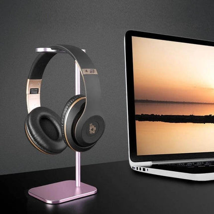 Aluminum Headset Stand For Desk Organization And Storage showing aluminum stand holding over-ear headphones beside laptop