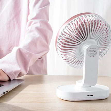 Quiet Automatic Shaking Desktop Fan for Home and Office Use on desk beside laptop providing quiet adjustable airflow