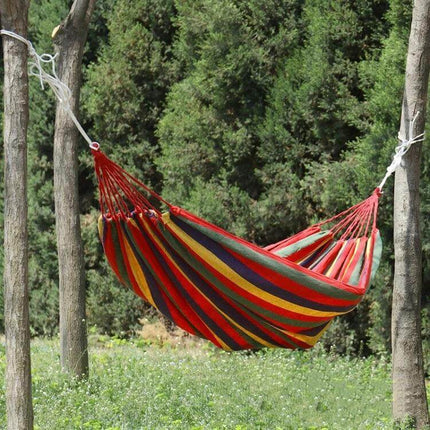 Thick Canvas Hammock For Outdoor Relaxation 260x150 in striped red and yellow canvas hung between trees for backyard lounging
