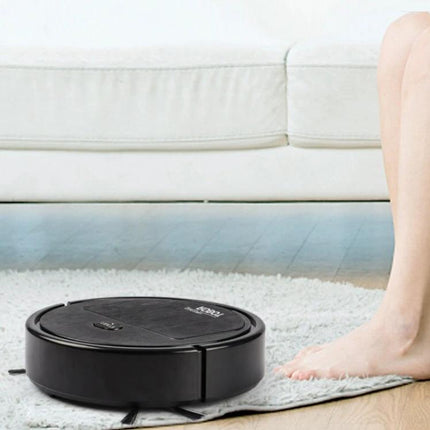 Automatic Black Sweeping Robot for Household Cleaning navigating under sofa on hardwood and rug, compact durable black design for daily floor care