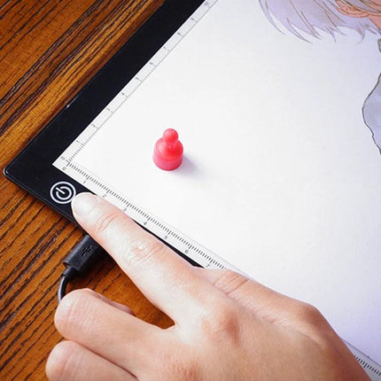 A4 Black LED Copy Board with Stepless Dimming for Drawing showing finger adjusting power button while tracing artwork on tabletop