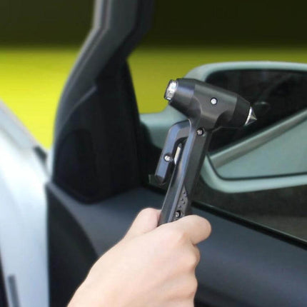Car Emergency Hammer for Window Breaking and Seat Belt Cutting held against car side window to break glass and cut seat belt for emergency escape