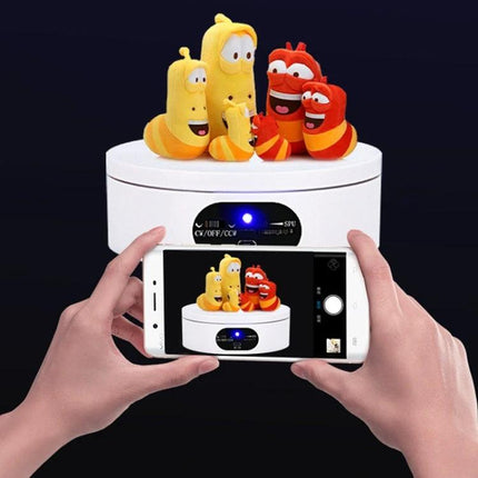 USB Rotating Turntable for Product Photography and Displays, 12cm showing plush toys on rotating platform with smartphone capturing 360° view