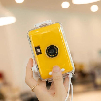 Vintage Waterproof Film Camera for Outdoor Photography Use in bright yellow with waterproof shell held by hand, durable ABS, 135 film, beach and hike ready