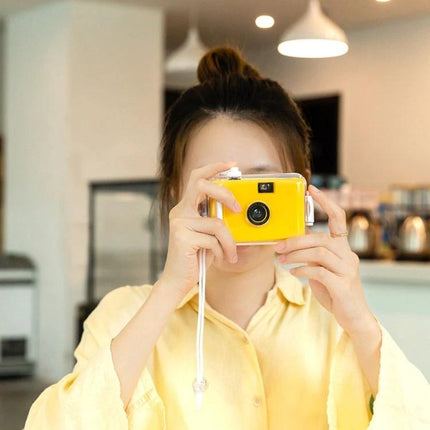 Vintage Waterproof Film Camera for Outdoor Photography Use - Woman Holding Yellow Waterproof 135 Film Camera Indoors