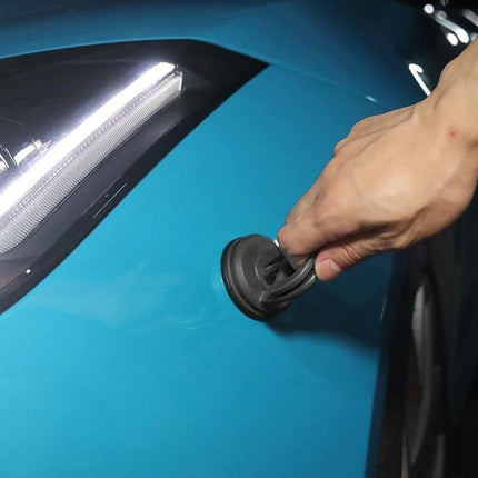 Compact Suction Cup for Home Car Dent Repairs in Daily Use - hand using suction cup to pull small dent from blue car panel