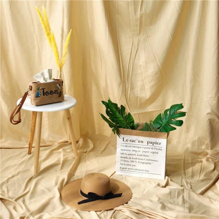 Solid Color Background Cloth for Photography, 1x2.4m Size used as beige studio backdrop with hat, stool, bag and green leaves