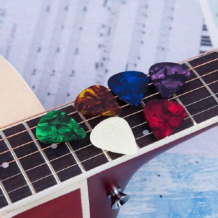 Guitar Picks for Everyday Music Practice at Home - colorful celluloid picks on acoustic guitar fretboard for clear, controlled strumming and picking