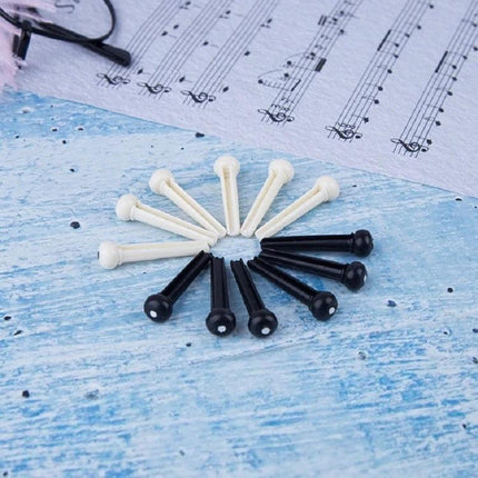 Plastic Conical Pins for Everyday Guitar String Maintenance — white and black ABS guitar bridge pins arranged on blue background