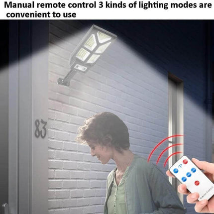Solar Body Induction Wall Light for Garden and Fence mounted on brick wall illuminating walkway with remote control and motion-activated lighting