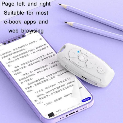 Versatile Car Key Shaped Bluetooth Remote for Selfies and Videos white compact remote on phone reading e-book demonstrating page turn control