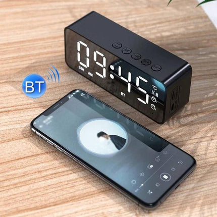 Bedside Mirror Alarm With Clock Display And Bluetooth Speaker showing large mirror time display next to smartphone playing music
