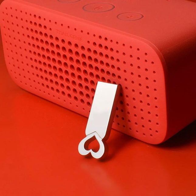Zshqu2 Heart-Shaped Metal USB Flash Drive for Everyday Storage plugged into a red speaker, compact metal heart-shaped USB for travel and backups