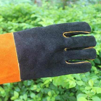 Alt Tag: Outdoor Garden Cut-Proof Genuine Leather Welding Gloves black and orange glove shown on green foliage background, durable cut and heat resistant protection