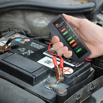 Handy Tool for Checking Car Battery During Daily Maintenance - small handheld battery tester clamped to car battery showing charge status