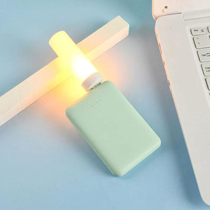 Four USB Flame Lamps for Cozy Evening Home Ambiance – glowing USB flame lamp plugged into power bank beside laptop