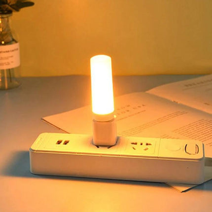 Four USB Flame Lamps for Cozy Evening Home Ambiance - single glowing USB flame lamp plugged into power strip on bedside table