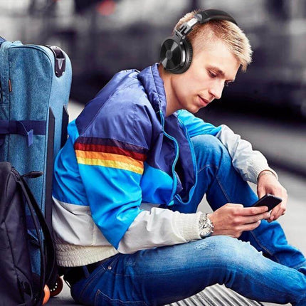 OneOdio Wireless Over Ear Headphones For Daily Commuting young commuter with backpack wearing foldable headphones and checking phone